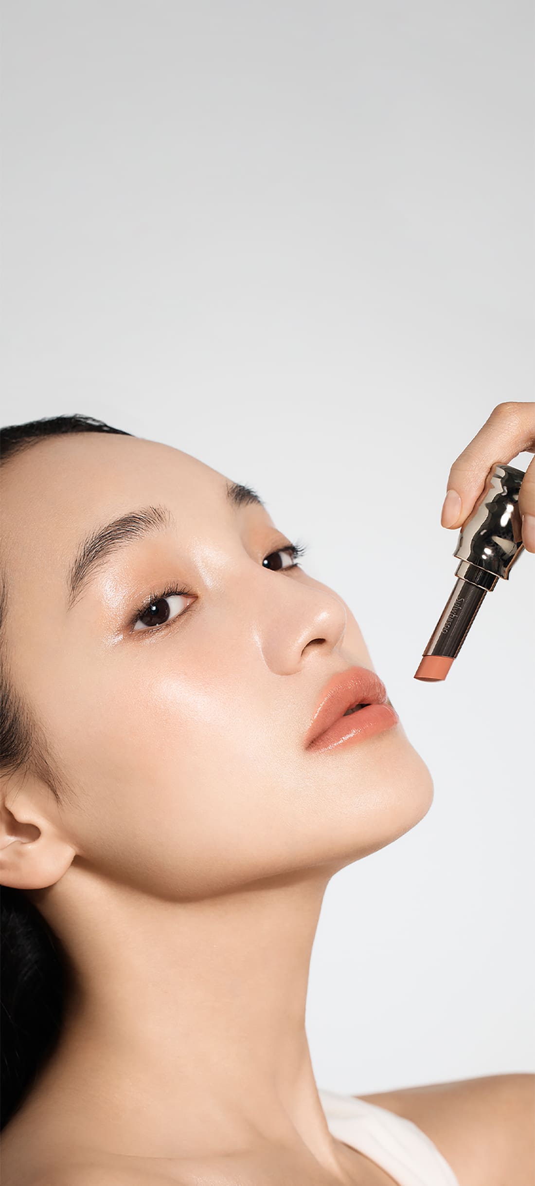 A model with Perfecting Lip Color NO.310 Terra in hand