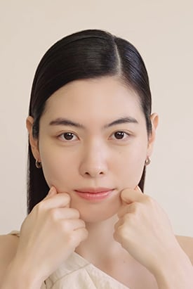 손으로 얼굴을 부드럽게 마사지하는 여성의 모습은 설화수 자음생크림의 탄력 있는 피부 효과를 시각적으로 보여줍니다.