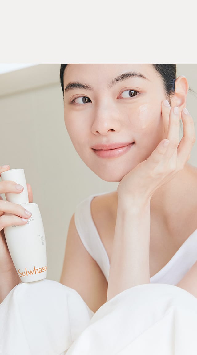 모델이 설화수 윤조에센스를 들고 볼에 제품을 바른 모습