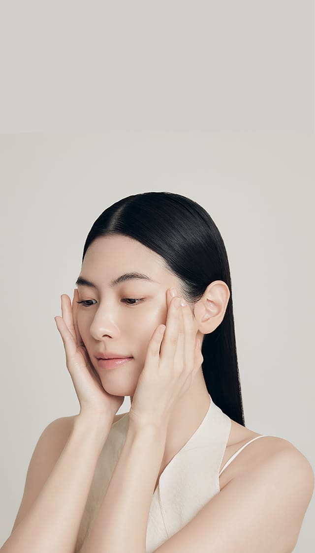 모델이 양손으로 얼굴을 감싸 스킨케어하는 모습