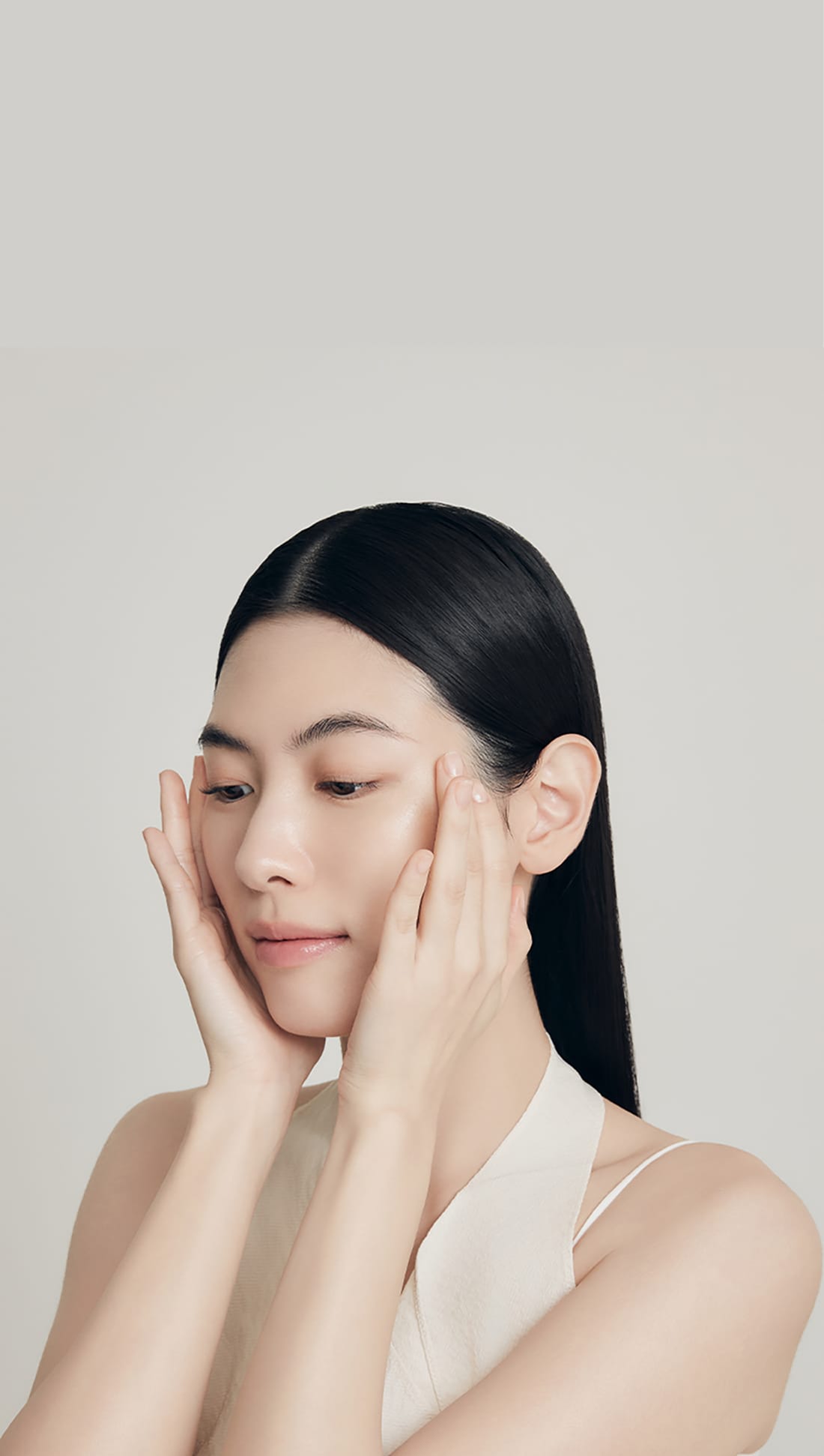 모델이 양손으로 얼굴을 감싸 스킨케어하는 모습