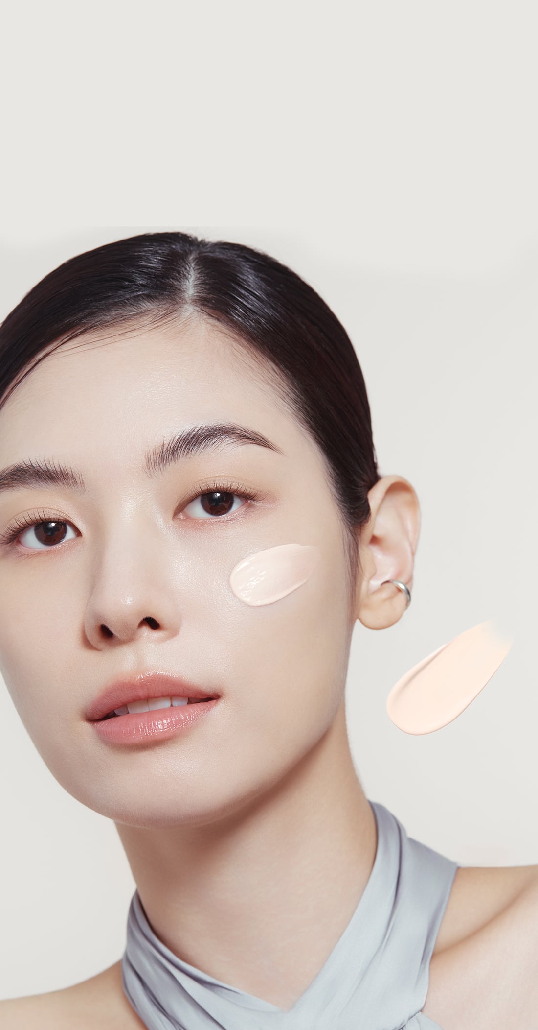 퍼펙팅 베일 프라이머를 얼굴에 도포하여 실제 피부톤과 비교하고 있다. 