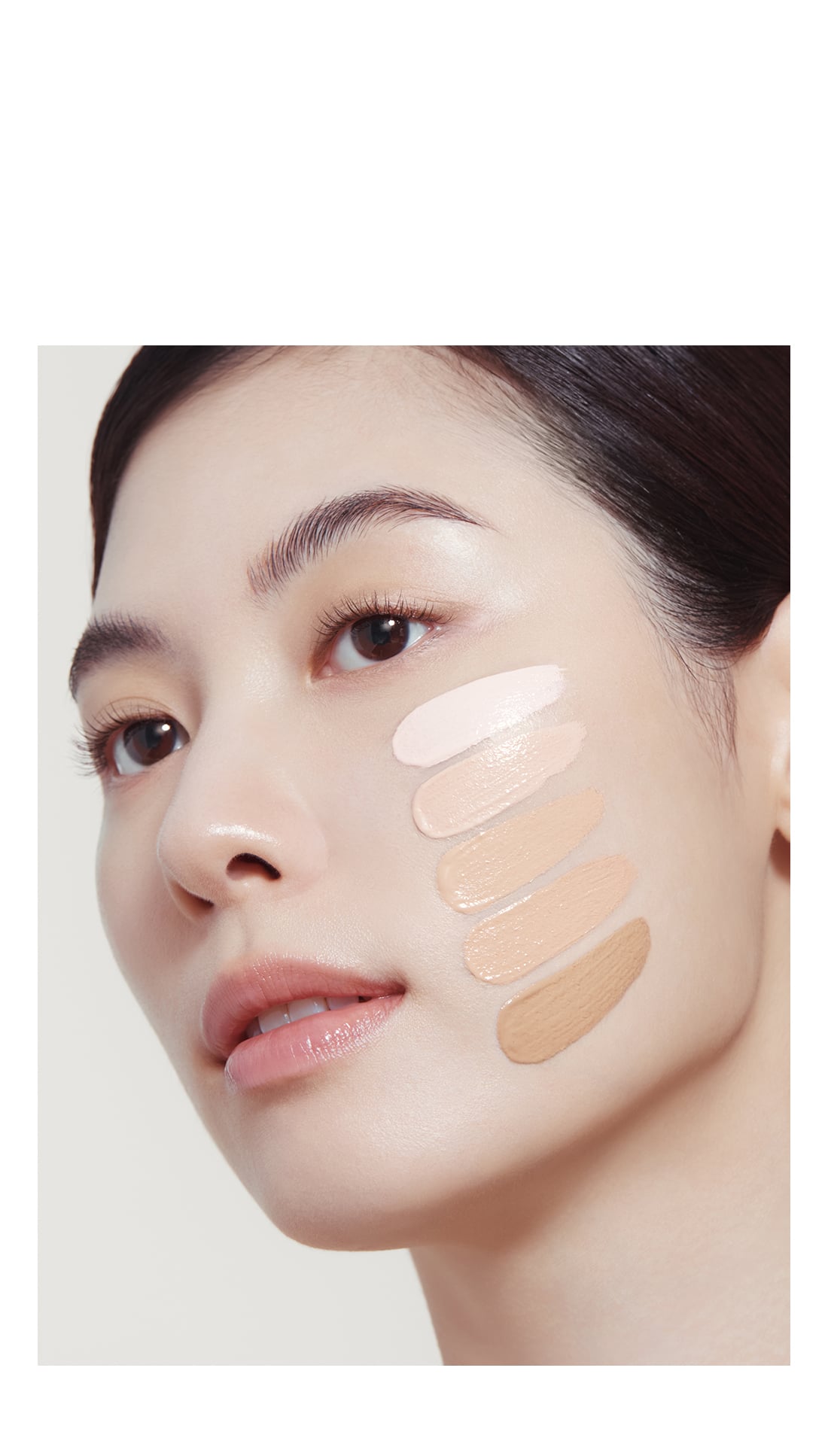 퍼펙팅 틴티드 크림 5종을 얼굴에 도포하여 실제 피부톤과 비교하고 있다. 